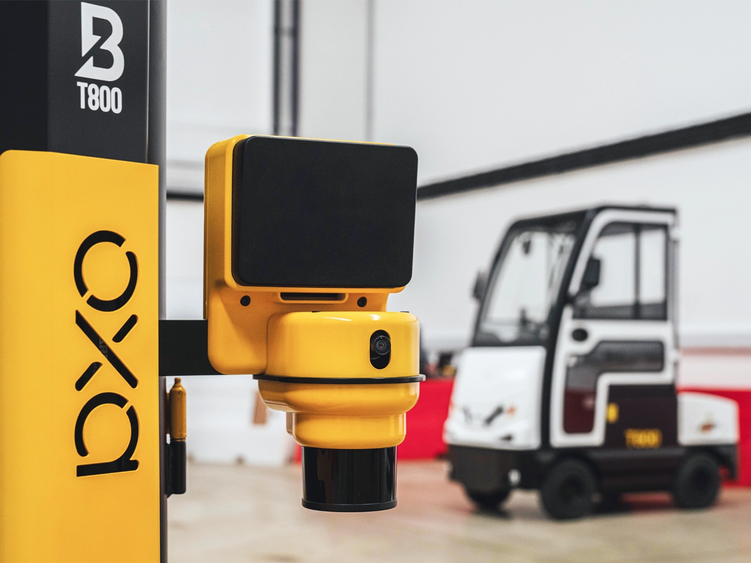 Oxa-Sensors Oxa-branded sensor unit mounted on a partner vehicle, photographed in an indoor test space.
